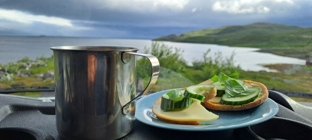 Kahvikuppi ja leivät matkailuauton ohjaamossa.